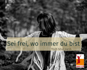 Stefanie sitzt auf dem Boden im Wald und breitet die Arme aus. Über dem Foto steht ein Spruch von Thich Nhat Hanh.